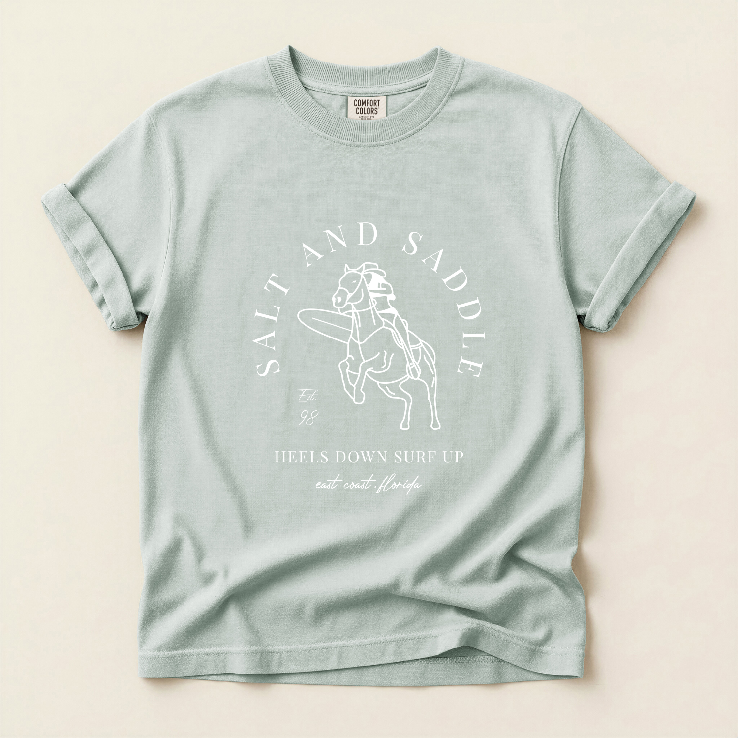 Light blue t-shirt with 'Salt and Saddle' graphic and text on a beige background
