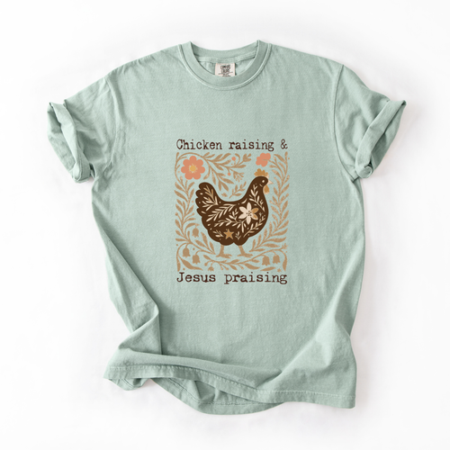 Light green t-shirt with a chicken and floral design on a white background