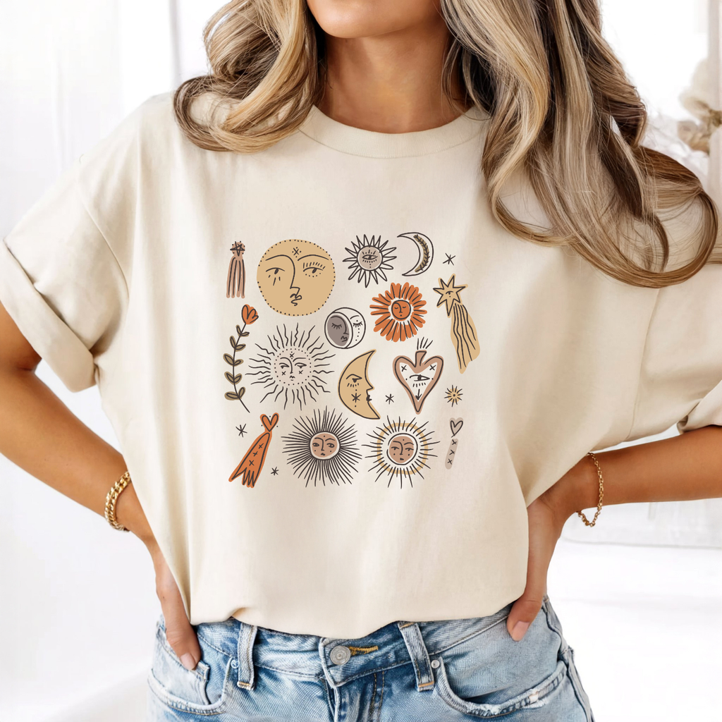 Boho celestial graphic tee featuring sun, moon, and stars design on a soft neutral women's t-shirt