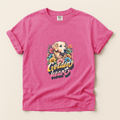 Pink t-shirt with a graphic of a golden retriever and flowers on a beige background