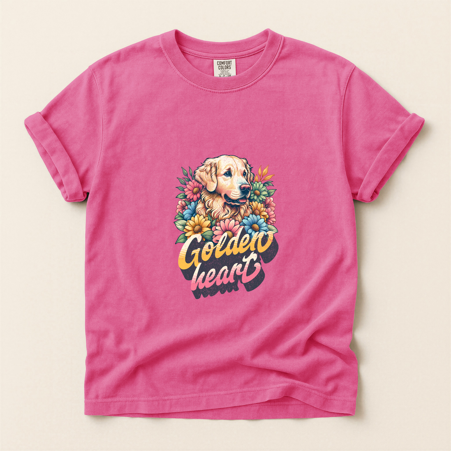 Pink t-shirt with a graphic of a golden retriever and flowers on a beige background