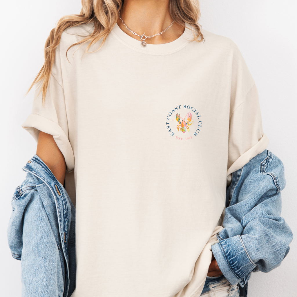 Ivory colored tee with a pastel colored preppy lobster illustration