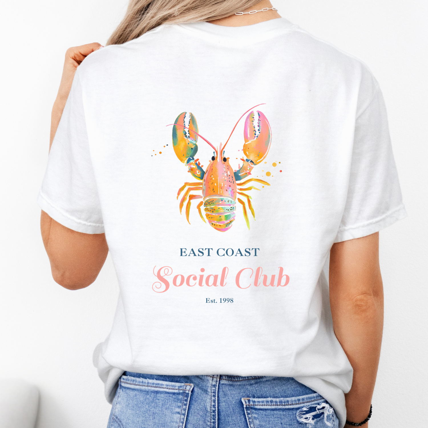 White comfort colors tshirt with a bright pink lobster and the words "east coast social club"