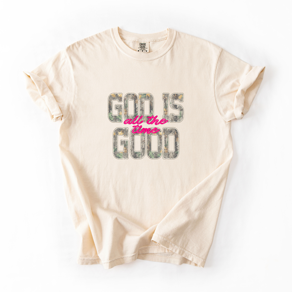 Beige t-shirt with 'God is all the time good' text on a white background