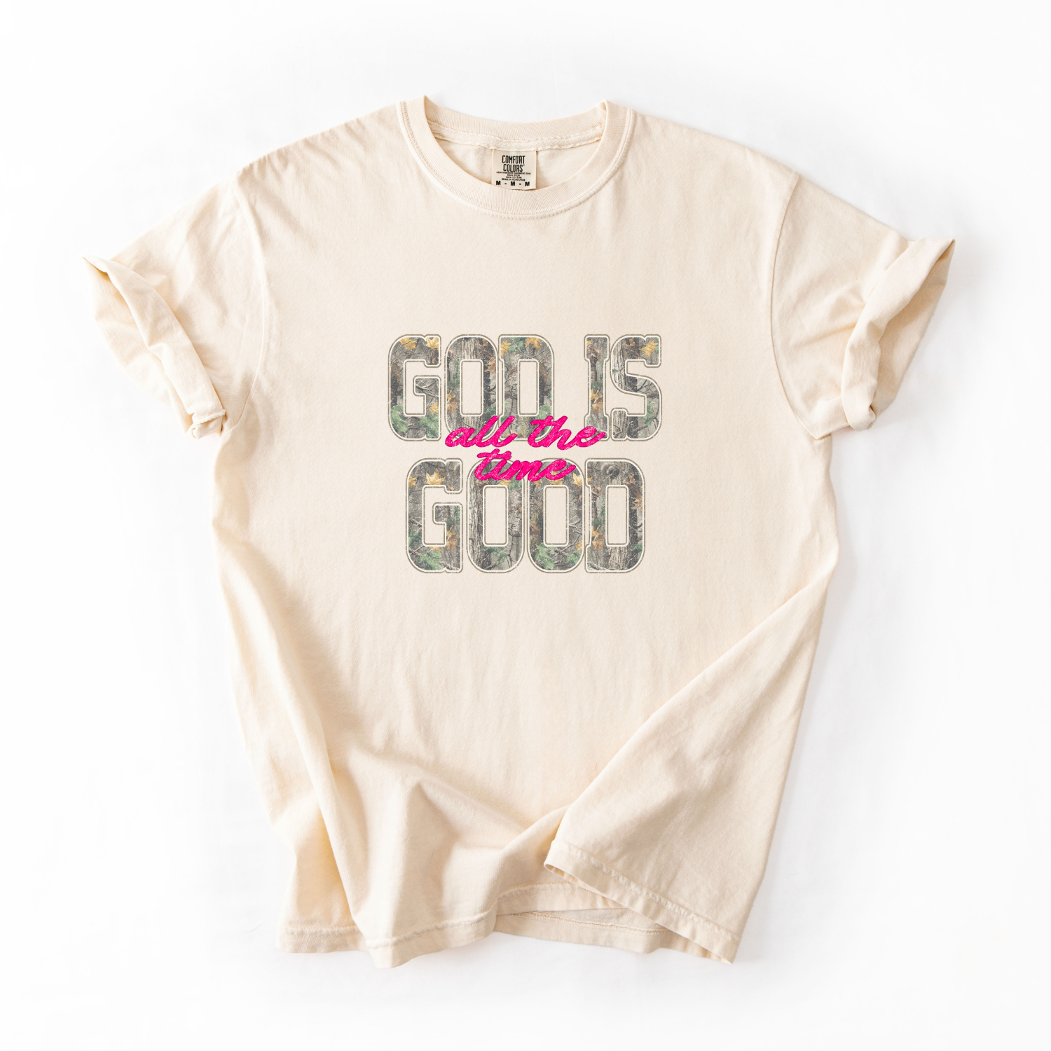 Beige t-shirt with 'God is all the time good' text on a white background