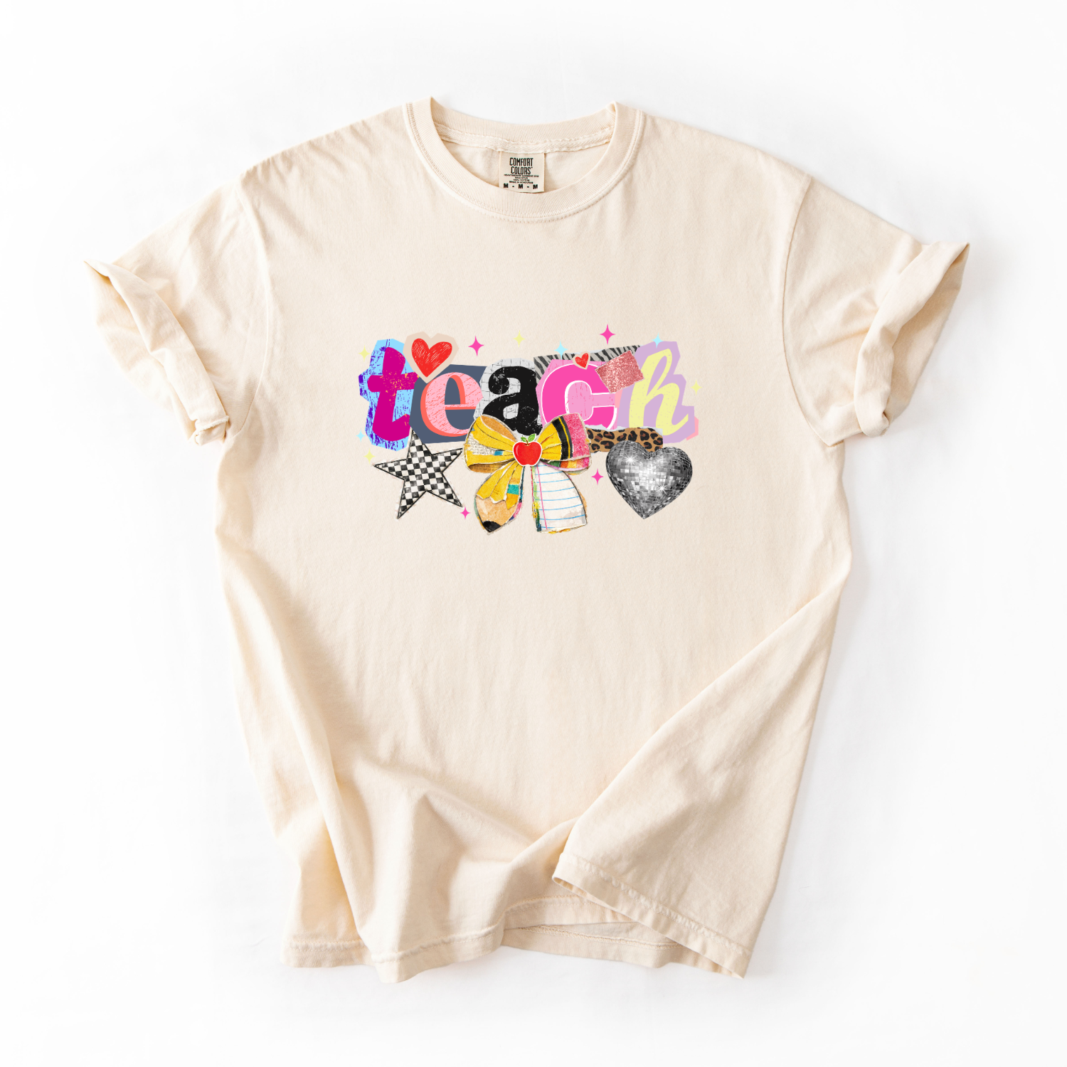 Beige t-shirt with colorful 'teach' graphic on a white background