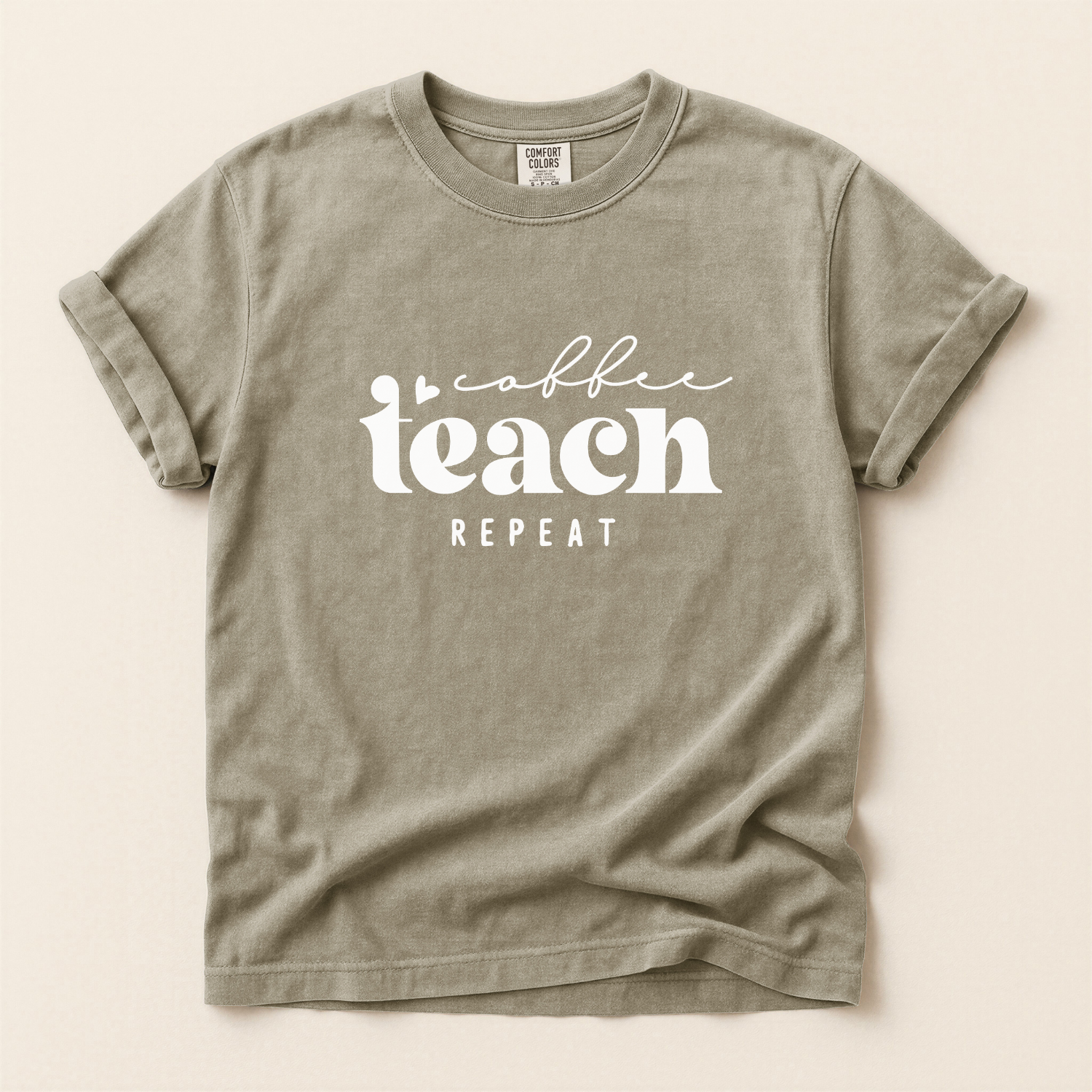 khaki t-shirt with 'coffee teach repeat' text on a beige background