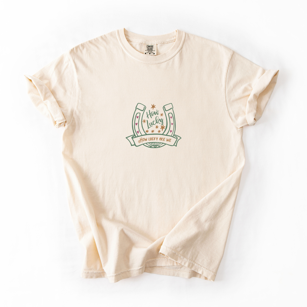 Ivory comfort colors shirt with a horseshoe and text that reads "how lucky are we"