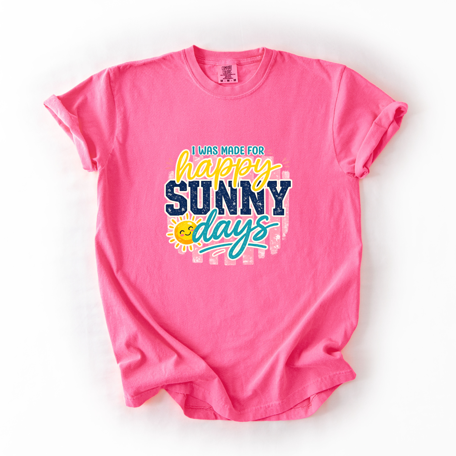 Pink t-shirt with 'I was made for happy sunny days' text on a white background