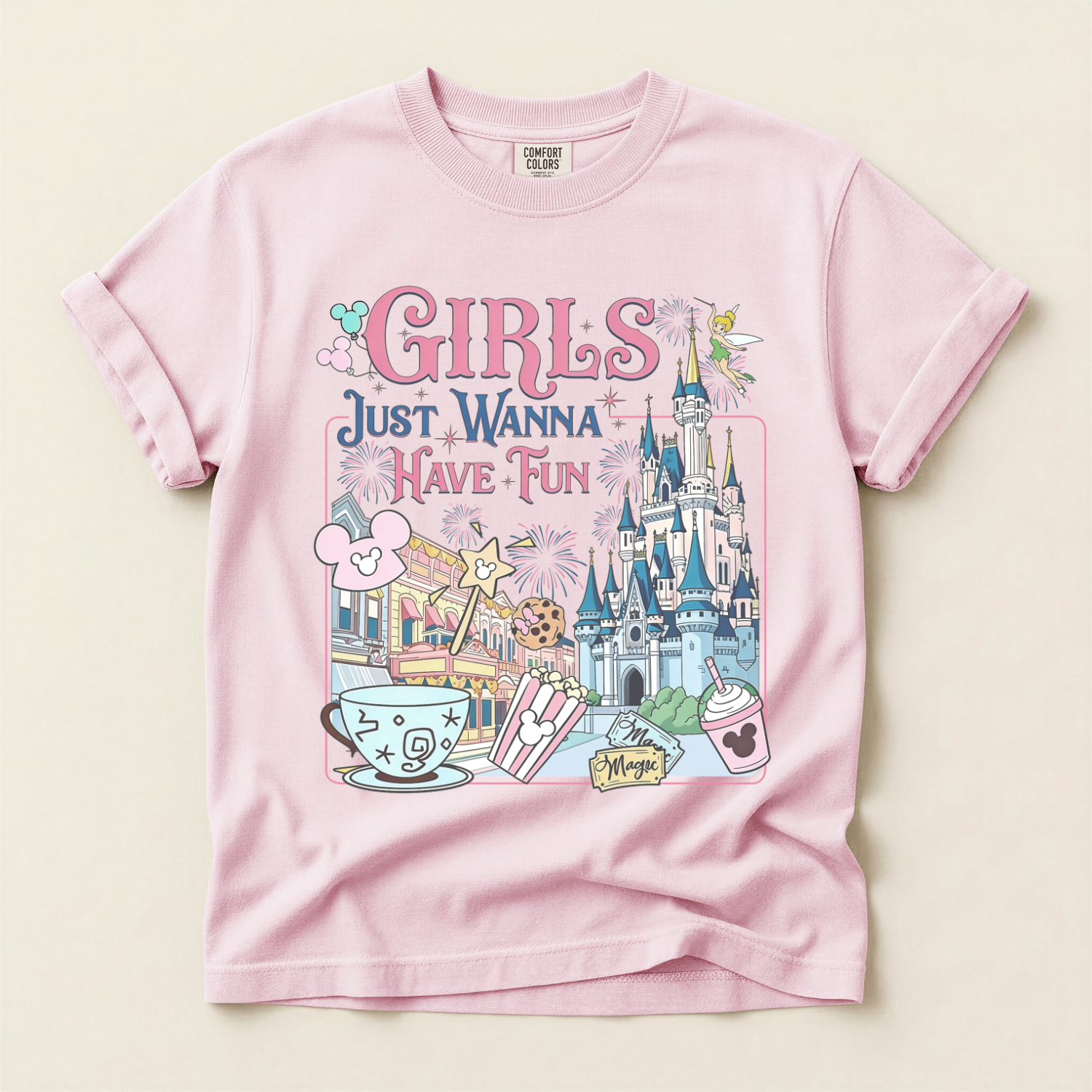 Pink t-shirt with a colorful graphic inspired by a day at disney with friends and 'Girls Just Wanna Have Fun' text on a light beige background