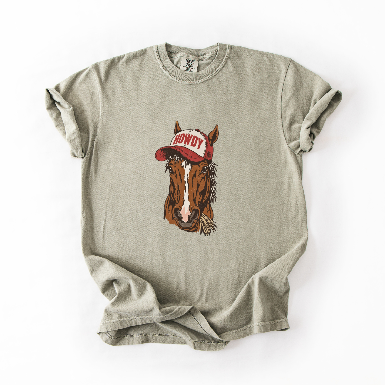 Beige t-shirt with a horse wearing a red 'Howdy' cap on a white background