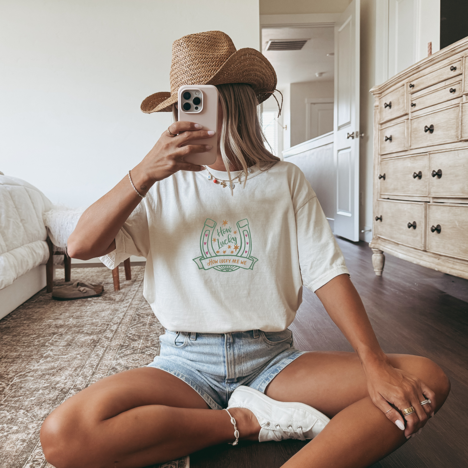 Western styled outfit with off white shirt that has a horseshoe with text that reads "how lucky"