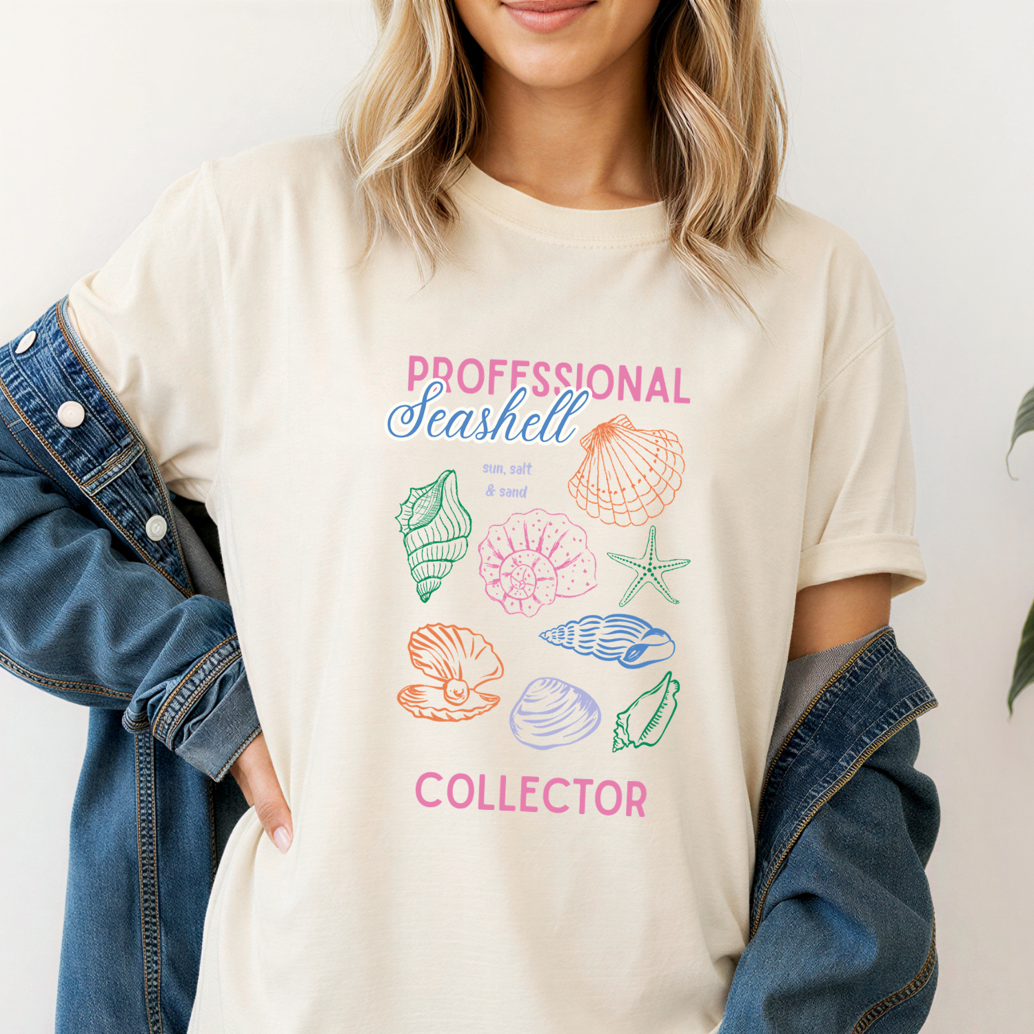 Comfort colors tee in Ivory with vintage seashell drawings in bright pink, orange, blue and green with the text "professional seashell collector"